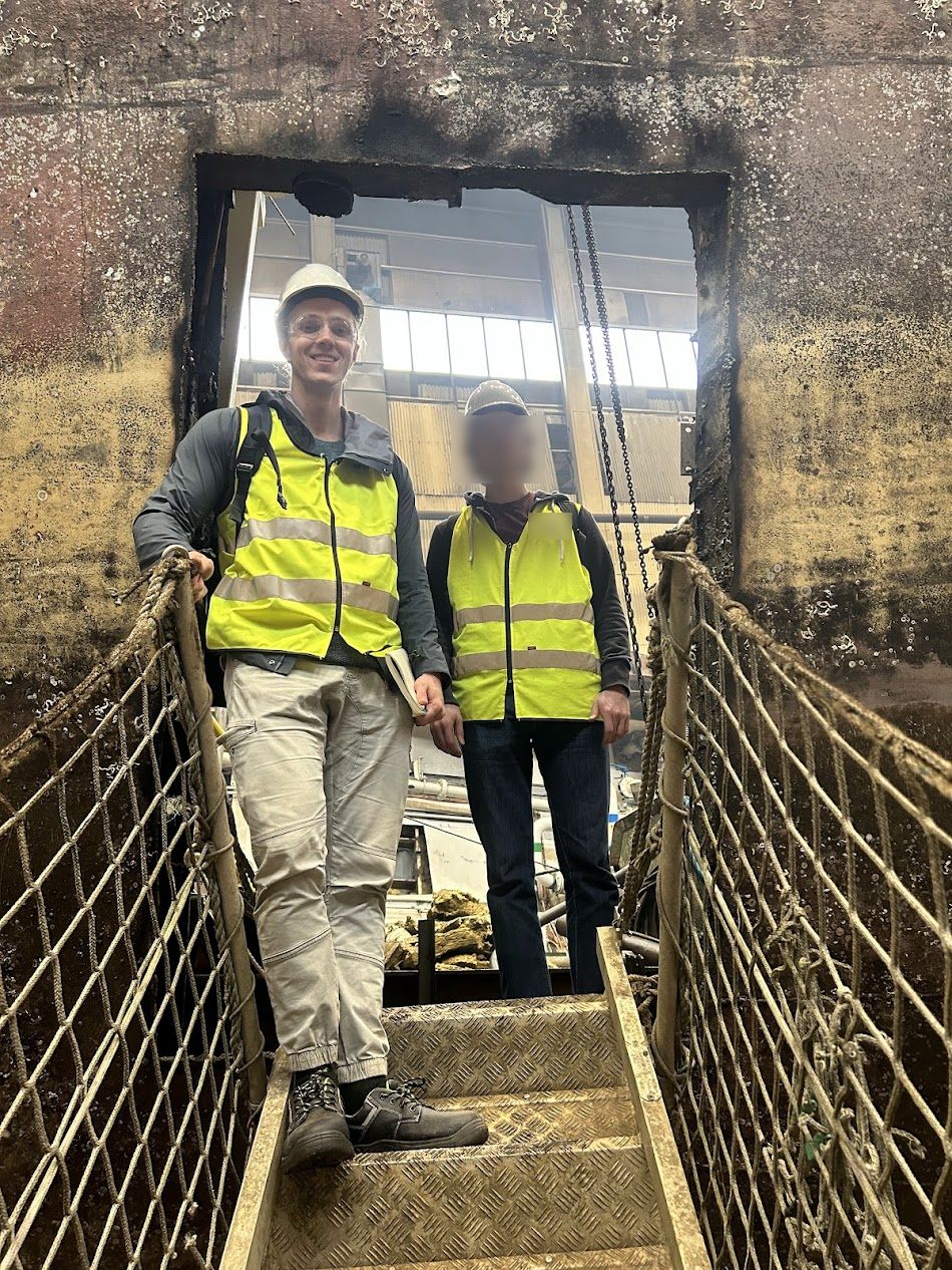 At an opening cut through the hull of a vessel mid-breakdown, on a field visit.